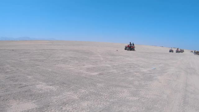 游客骑着四轮沙滩车在埃及沙漠旅行。访问一个贝都因村庄视频素材