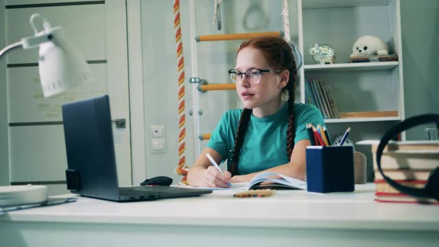 十几岁的女孩在家里用笔记本电脑远程学习视频素材