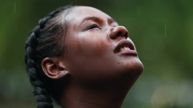 满怀希望的黑人女孩在雨中祈祷。忠实的年轻非洲妇女在下雨时祈祷视频素材