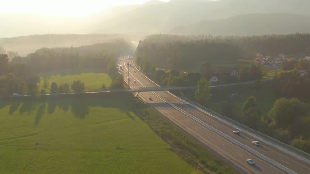 无人机:日出照亮了在乡村高速公路上开车的通勤者。视频素材