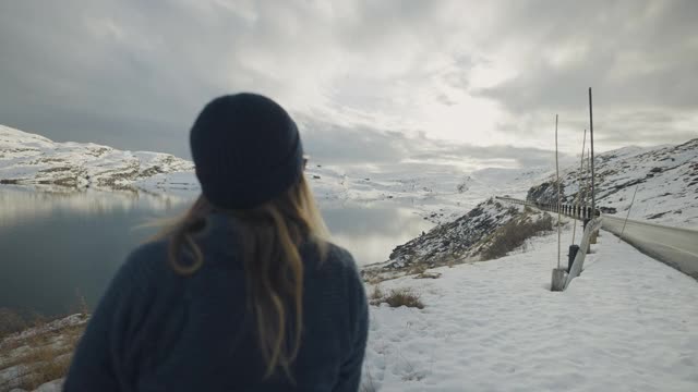 在挪威的湖边徒步旅行的女人:冬天的颜色和心情视频素材