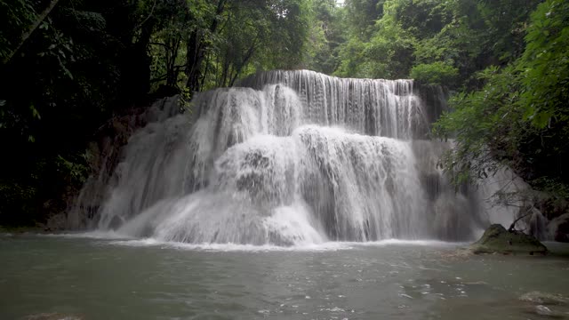 在泰国北碧府的怀美卡明瀑布的自然公园里，可以欣赏到美丽的热带雨林瀑布，柔和的溪水。视频素材