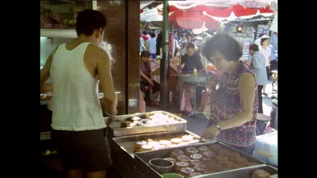 一名妇女在香港街头小吃摊上买月饼视频素材