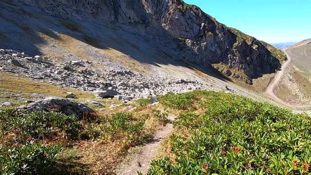 沿着山顶走。在明亮的蓝色天空的背景下，秋天五颜六色的全景山。在山中漫步视频素材