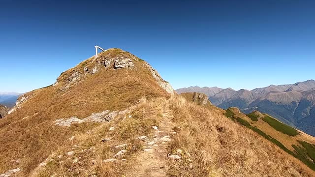 沿着山顶走。色彩斑斓的全景式山峰在秋季明亮的蓝色天空视频素材