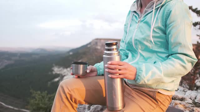 徒步女在山上喝茶。视频素材