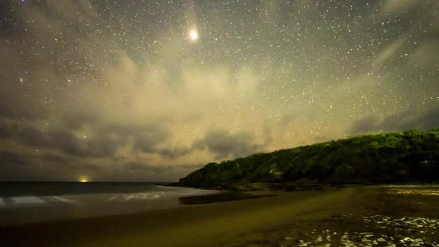 海滩上的星星、云彩和行星的夜晚时间流逝视频素材