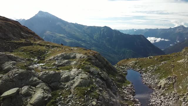 奥地利Hohe Tauern地区斜坡的全景照片。山坡部分被雪覆盖着。上部陡峭而尖锐。阿尔卑斯山的早春。中间有一个小湖视频素材