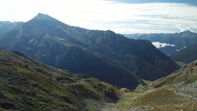 奥地利Hohe Tauern地区斜坡的全景照片。山坡部分被雪覆盖着。上部陡峭而尖锐。阿尔卑斯山的早春。中间有一个小湖视频素材