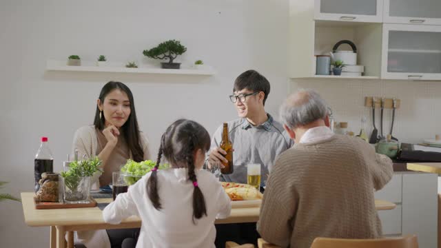 远景:快乐的亚洲家庭一起享用早餐。快乐的父母，爷爷和可爱的女儿在家里的餐桌上一起享用早餐。美妙的时刻家庭视频素材