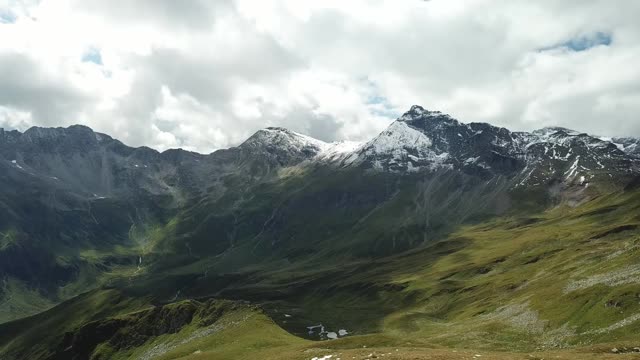 这是奥地利Hohe Tauern地区山谷的全景照片。郁郁葱葱的绿色山谷。较高的山坡部分被雪覆盖。上部陡峭而尖锐。阿尔卑斯山的早春。冷静视频素材