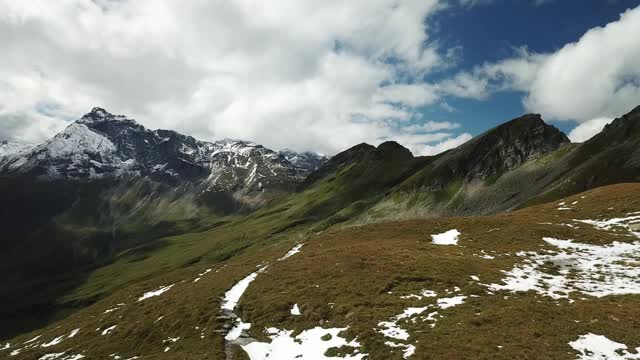 这是奥地利Hohe Tauern地区山谷的全景照片。郁郁葱葱的绿色山谷。较高的山坡部分被雪覆盖。上部陡峭而尖锐。阿尔卑斯山的早春。冷静视频素材