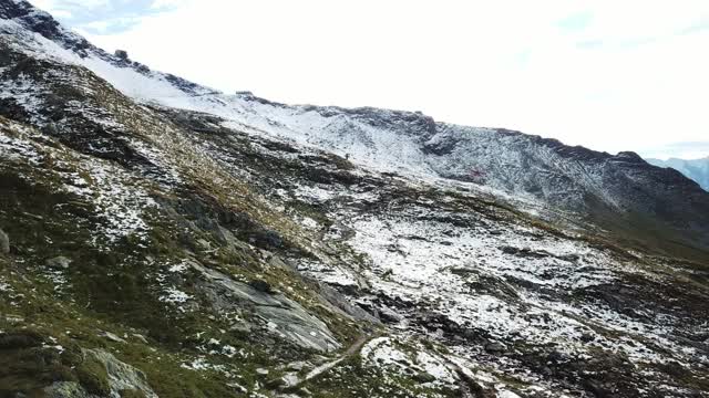 在奥地利Hohe Tauern地区的全景无人机拍摄的斜坡。山坡部分被雪覆盖着。上部陡峭而尖锐。阿尔卑斯山的早春。平静和冷静视频素材