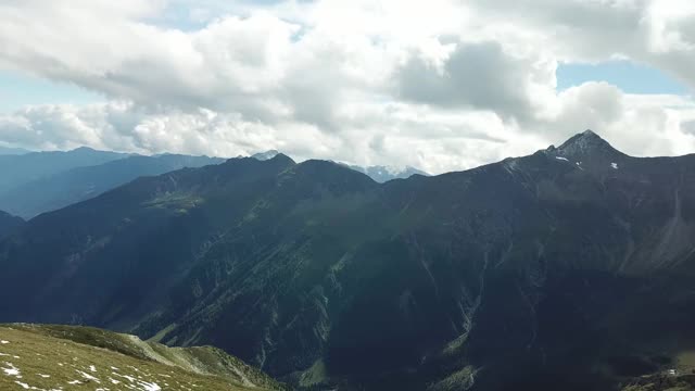 这是奥地利Hohe Tauern地区山谷的全景照片。郁郁葱葱的绿色山谷。较高的山坡部分被雪覆盖。上部陡峭而尖锐。阿尔卑斯山的早春。冷静视频素材