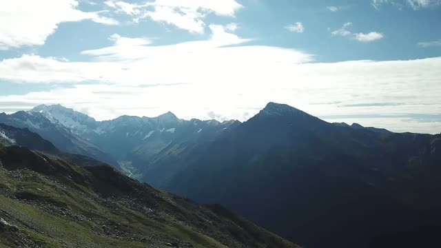 奥地利Hohe Tauern地区斜坡的全景照片。山坡部分被雪覆盖着。上部陡峭而尖锐。阿尔卑斯山的早春。中间有一个小湖视频素材