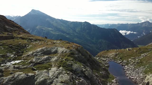 奥地利Hohe Tauern地区斜坡的全景照片。山坡部分被雪覆盖着。上部陡峭而尖锐。阿尔卑斯山的早春。中间有一个小湖视频素材