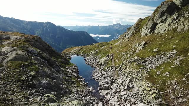 奥地利Hohe Tauern地区斜坡的全景照片。山坡部分被雪覆盖着。上部陡峭而尖锐。阿尔卑斯山的早春。中间有一个小湖视频素材