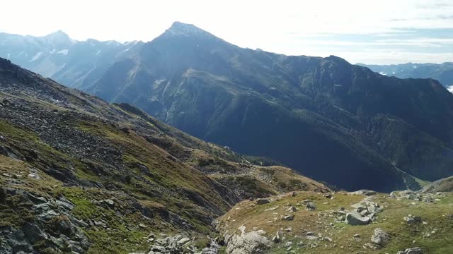 奥地利Hohe Tauern地区斜坡的全景照片。山坡部分被雪覆盖着。上部陡峭而尖锐。阿尔卑斯山的早春。中间有一个小湖视频素材