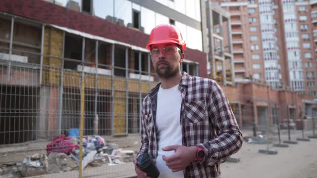 大胡子建筑工表情表情手势在建筑工地。建筑师在头盔中愤怒和疯狂，挥舞着失望和愤怒的手，尖叫着愤怒，愤怒和侵略性。视频素材