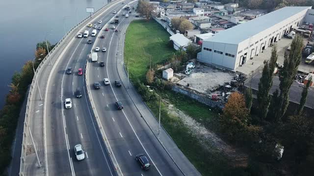 飞过高速公路，沿河而上的工业区对面是秋天乌克兰基辅的一座铁路桥视频素材