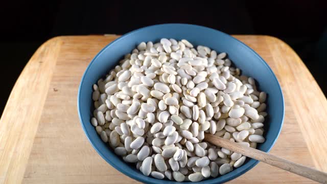 白豆是用木勺分类的。高蛋白的豆类，豆类和扁豆的健康饮食。视频素材