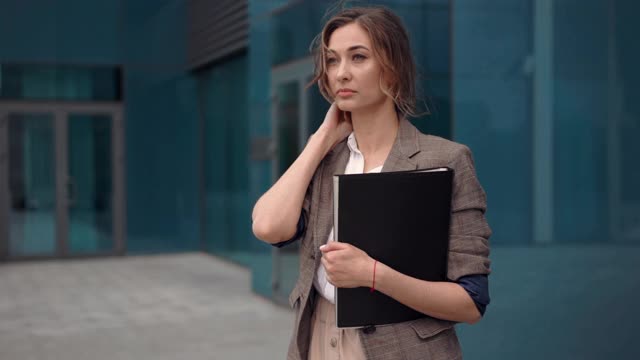 女商人成功的女商人站在户外公司大楼的外部。兴奋的白人自信职业女性中年视频素材