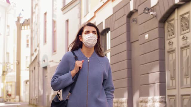 戴着医用口罩的女人走在城市里视频素材