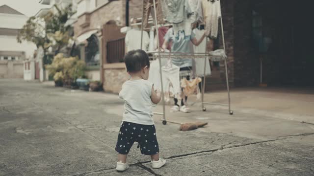 小男孩帮妈妈晾洗好的衣服视频素材