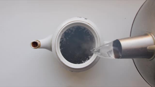 将热水倒入茶壶中，加入红茶视频素材