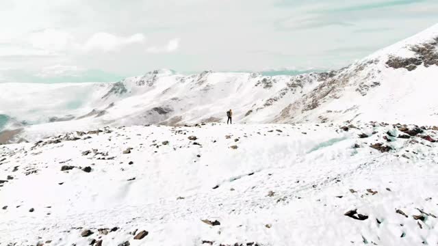 一名徒步旅行者在西班牙比利牛斯山脉的雪中用无人机记录下自己的生活。视频素材