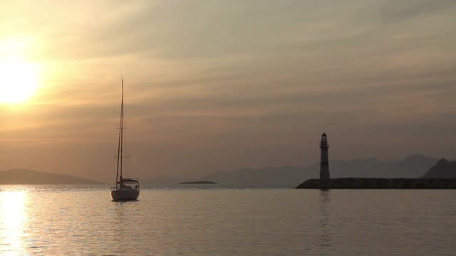 在夕阳海景。海岸上的灯塔。海边小镇Turgutreis和壮观的日落视频素材