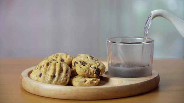 木盘上的巧克力饼干配黑咖啡。视频素材