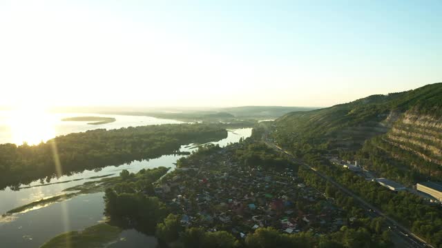 鸟瞰图，山上有绿色植物和一条河。住宅建筑和公路均位于山区，风景秀丽。视频素材