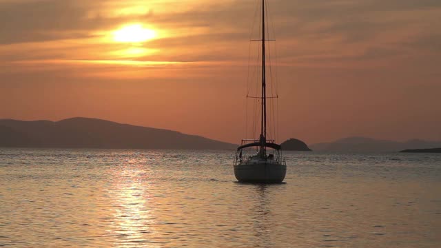 独自在夕阳下航行。大气海景与橙色的太阳。视频素材