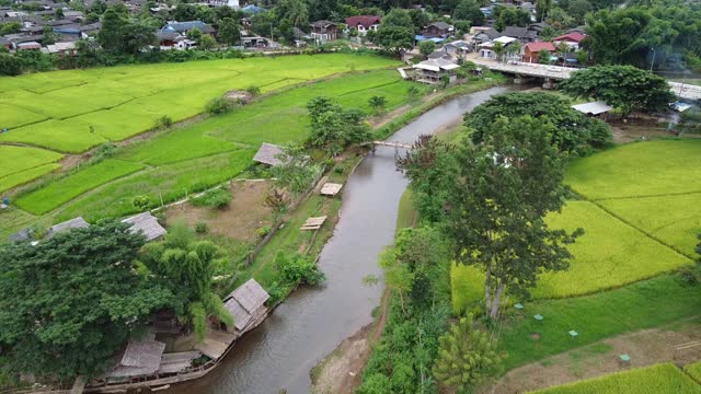 无人机鸟瞰乡村山村的河流和稻田视频素材