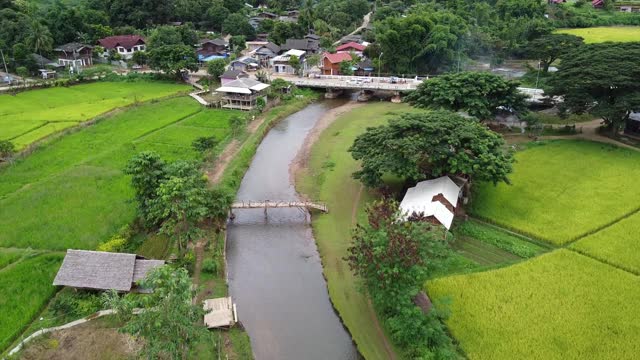 无人机鸟瞰乡村山村的河流和稻田视频素材