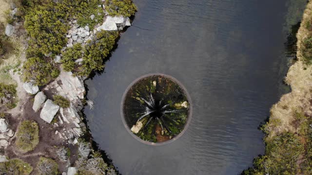 在Serra da Estrela的Covao dos Conchos水坝湖上，一架无人机在一个巨大的泄洪道上旋转视频下载