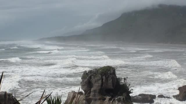 海浪在岩石海岸和山脉新西兰。视频素材