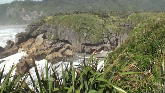 海浪在岩石海岸和山脉新西兰。视频素材