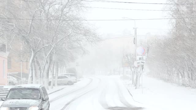 Вlizzard，雾和雪在城市，汽车在雨夹雪道路上，能见度差，冬季天气恶劣视频素材