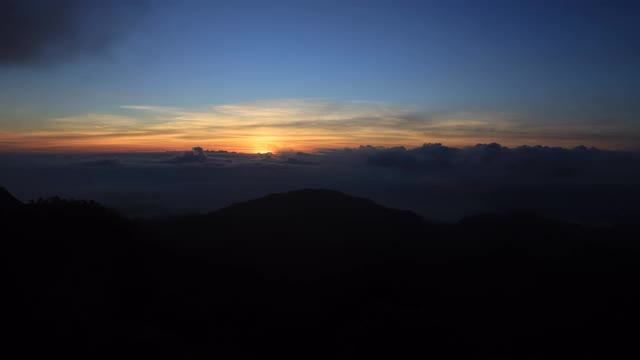 美丽的橙色和蓝色天空的日出在早上的山脉和蓬松的云运动与阳光和镜头光晕，时间流逝4K视频素材