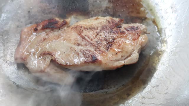 4K，热锅上烤猪肉，翻过来煮视频素材