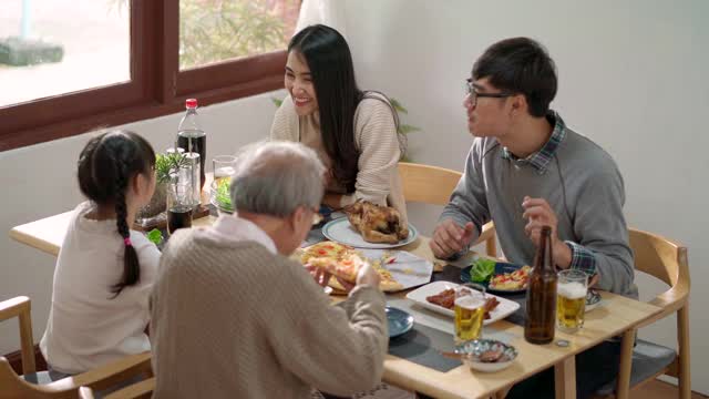 4K超高清手持高角度视角:幸福的亚洲多代家庭一起在家里吃饭。视频素材