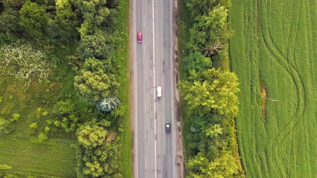 绿树间行驶车辆的道路鸟瞰图。视频素材