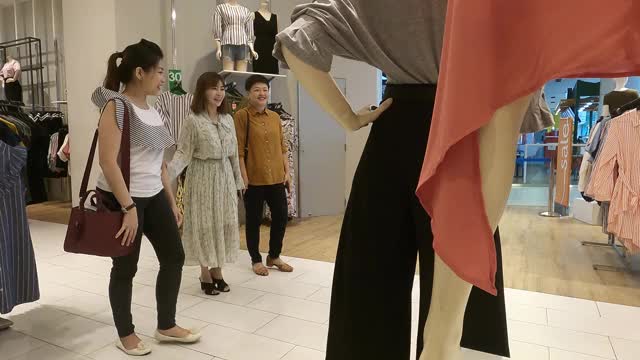 3名亚裔华人女性在服装店选购衣服视频素材