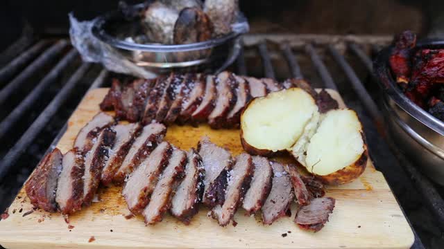 近距离烧烤排骨，猪肉和土豆在木材和木炭烤架上视频素材