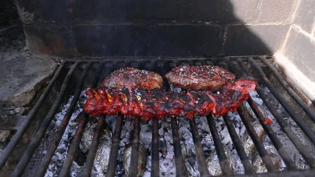 近距离烧烤肋骨和猪肉在木材和木炭烤架上视频素材