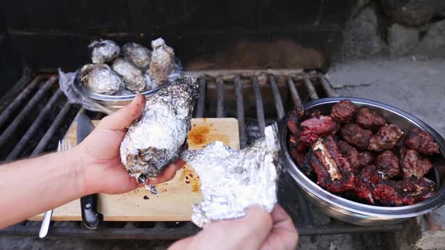 近距离烧烤排骨，猪肉和土豆在木材和木炭烤架上视频素材