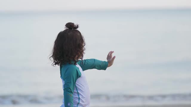 4K亚洲家庭假期快乐。可爱的小女孩穿着泳衣在沙滩上跑步和坐着玩沙子和海水。可爱的孩子女孩放松和有乐趣的夏季旅行旅行视频下载