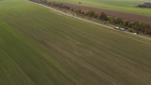 无人机拍摄的道路，移动的汽车和绿地。高速公路，田野和树木。视频素材